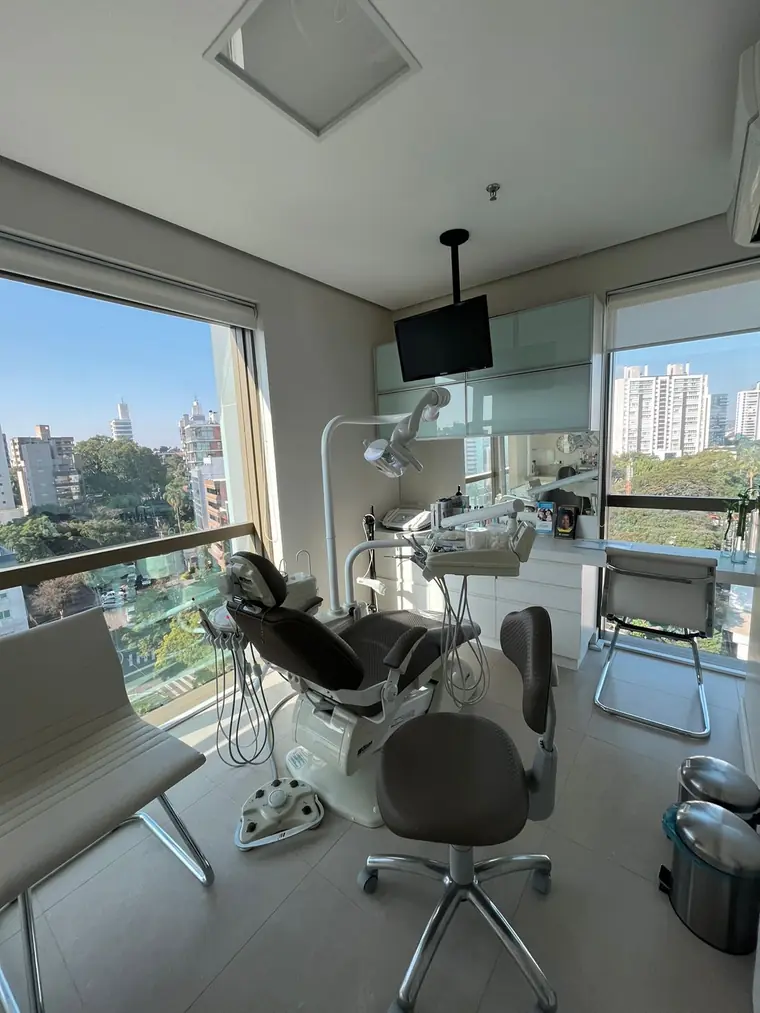 Sala clínica com janela ampla e vista para a cidade